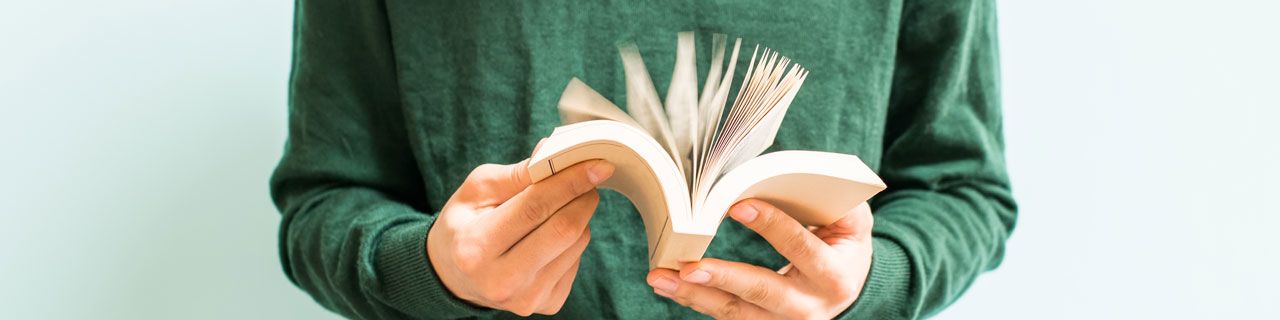 Mensch mit offenem Buch in der Hand