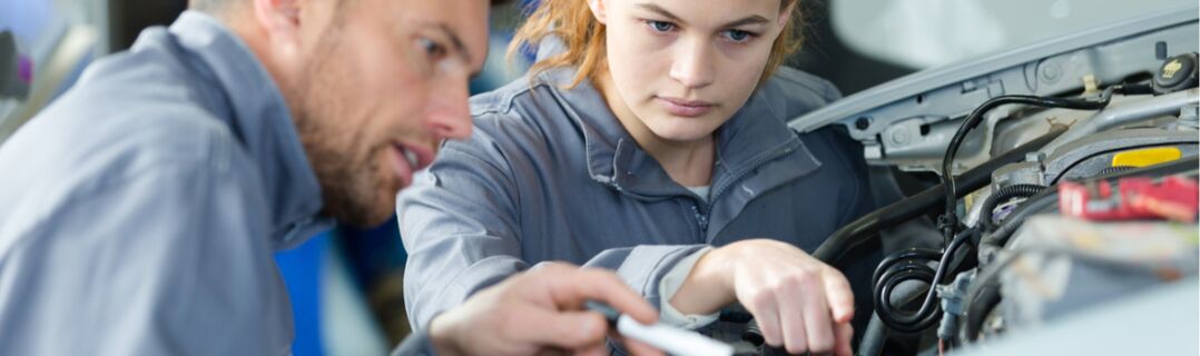 Ausbilder zeigt seiner Auszubildenden etwas