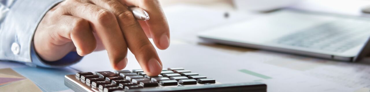 Mann der mit Taschenrechner rechnet