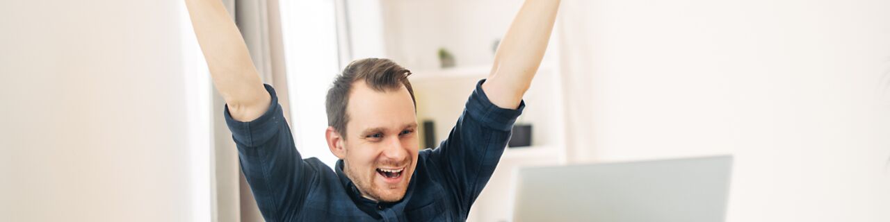 Mann reißt Hände in die Höhe